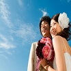 青空をバックに立つ新郎新婦