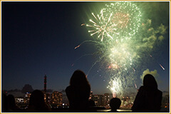 夜空の花火とそれを見上げる人々