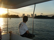 東京湾のデッキで夕日を見つめるお客様