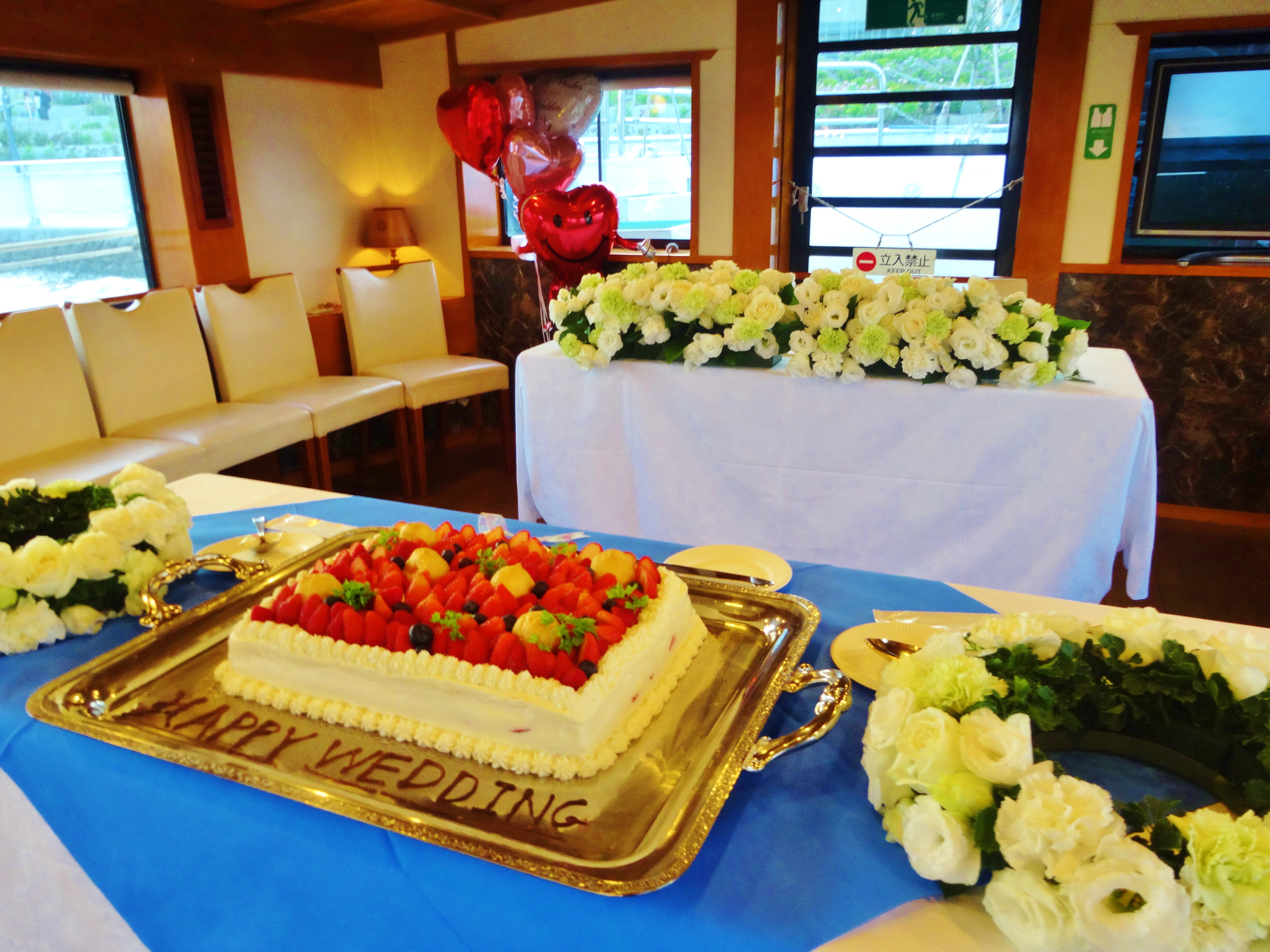 花やバルーンで装飾された船内に大きなケーキが置いてある