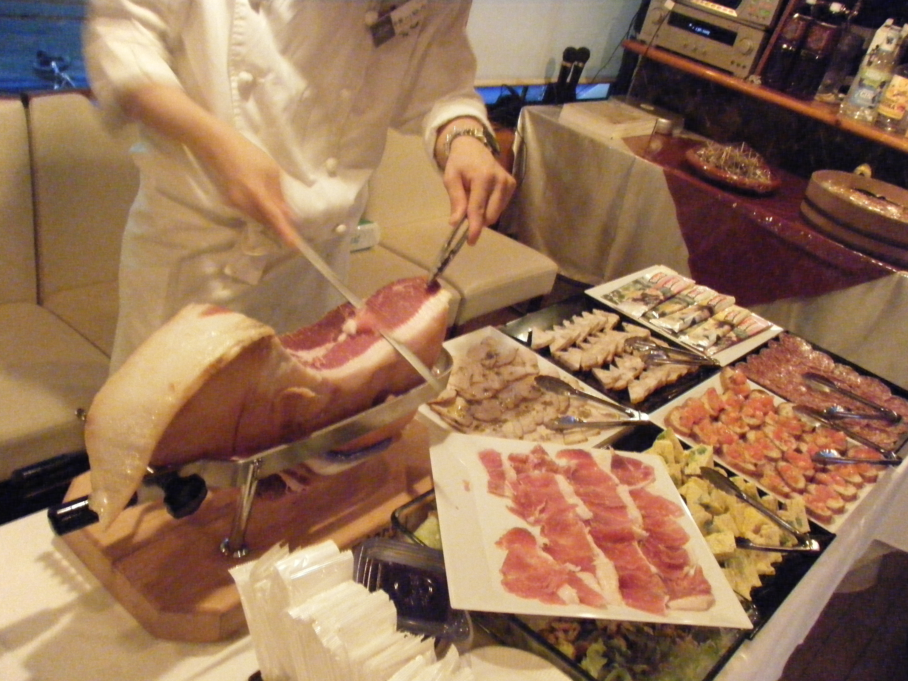 大きな肉を切り分けるシェフと並ぶ料理