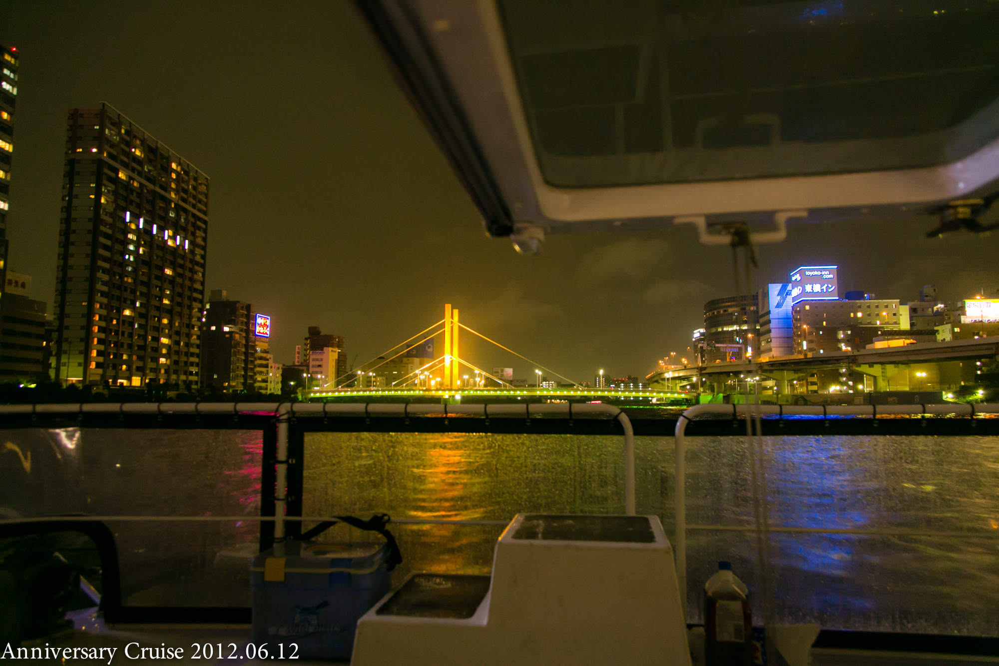 船のデッキから見えるライトアップされた橋や街の夜景