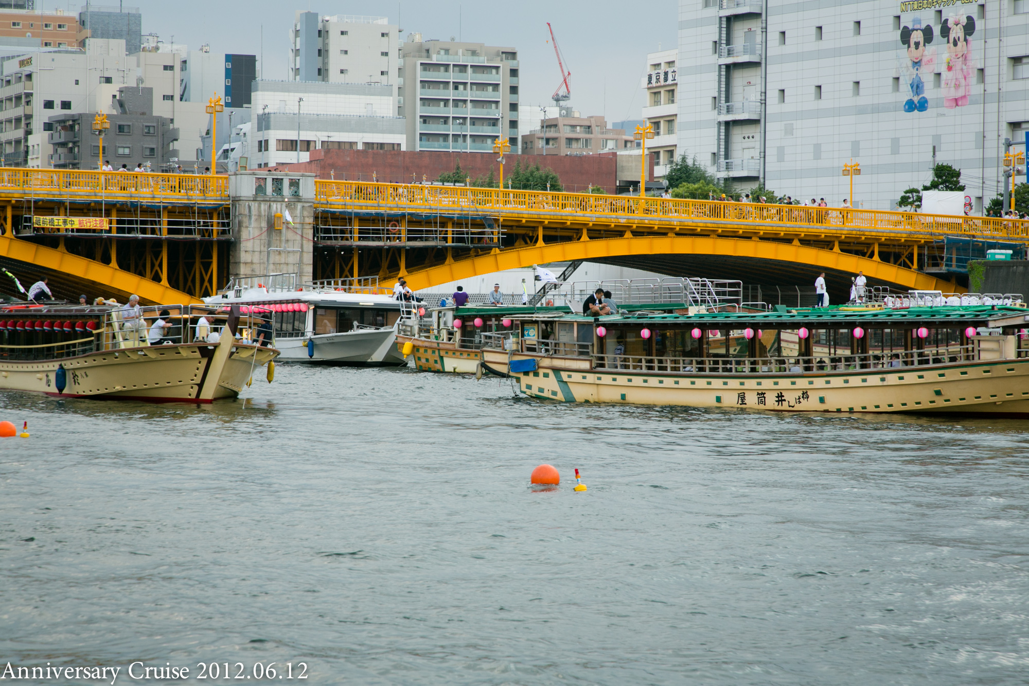 黄色い橋の付近で停泊するたくさんの屋形船