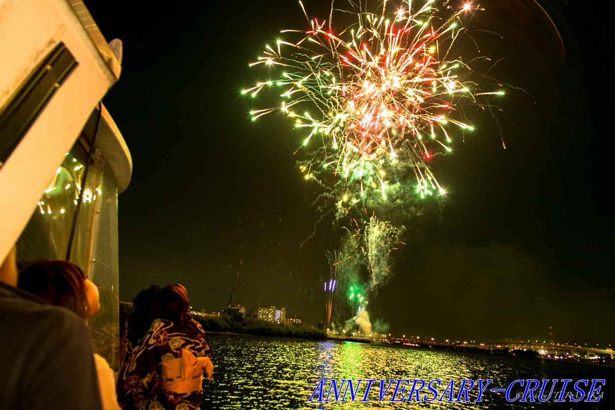 間近であがる打ち上げ花火を船の上から見る浴衣姿の女性