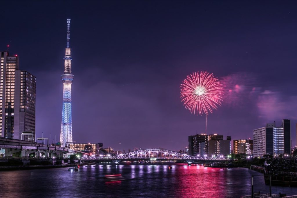 ライトアップされたスカイツリーと赤い花火