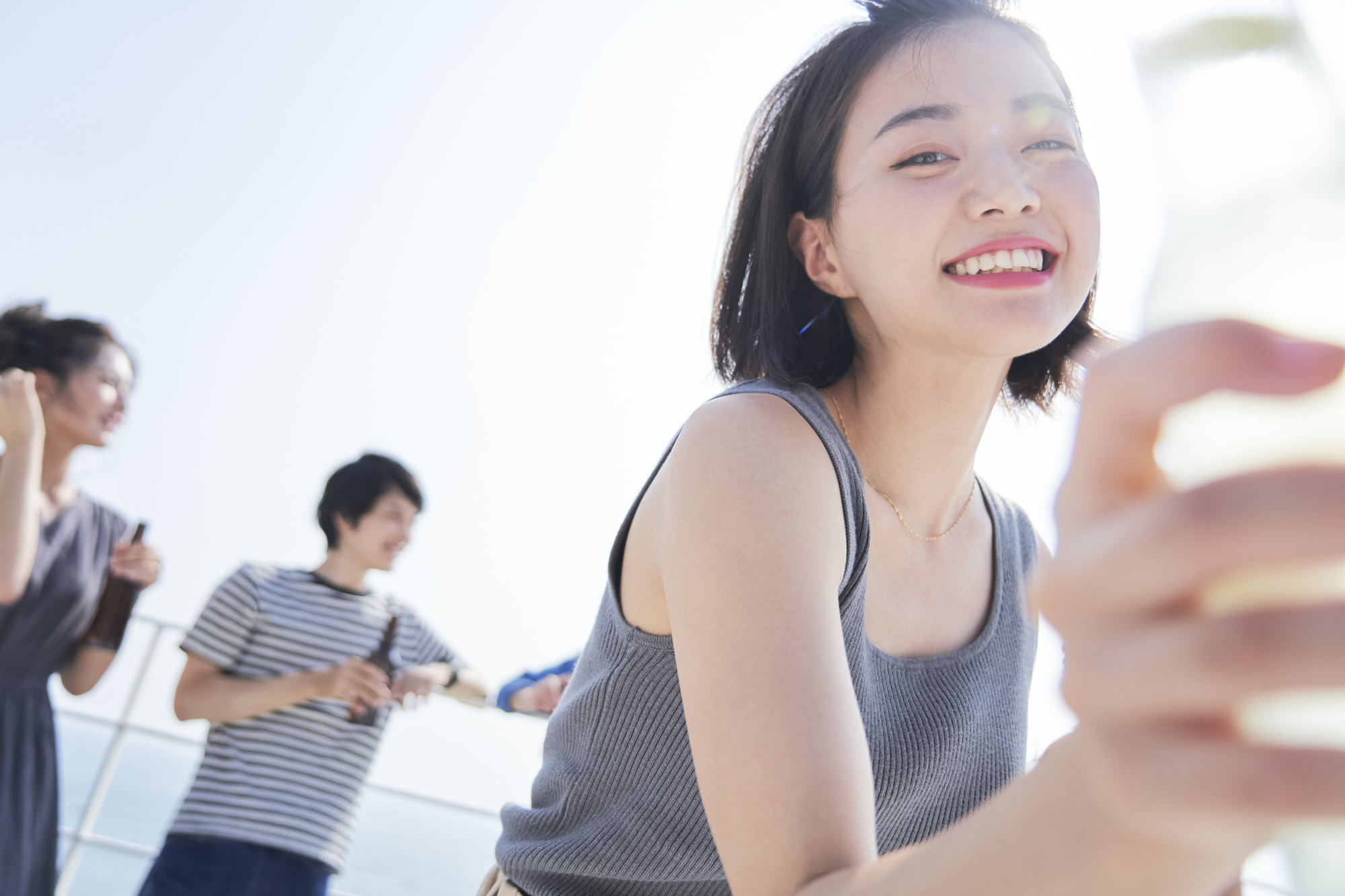 デッキでドリンクを持つ女性