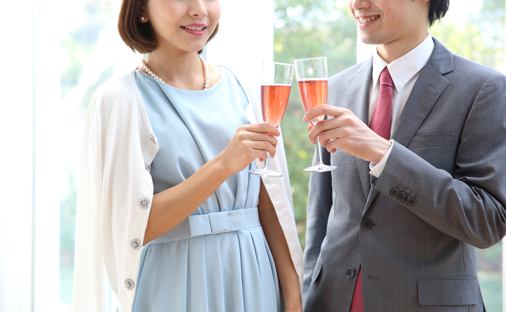 ドレスアップした男女がシャンパンで乾杯