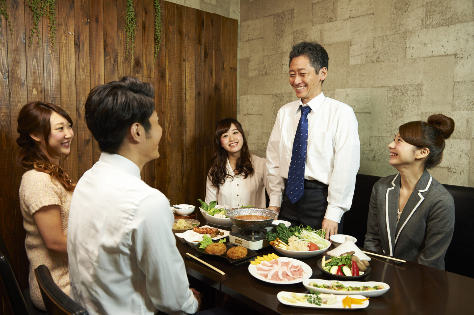 飲み会で挨拶をする様子