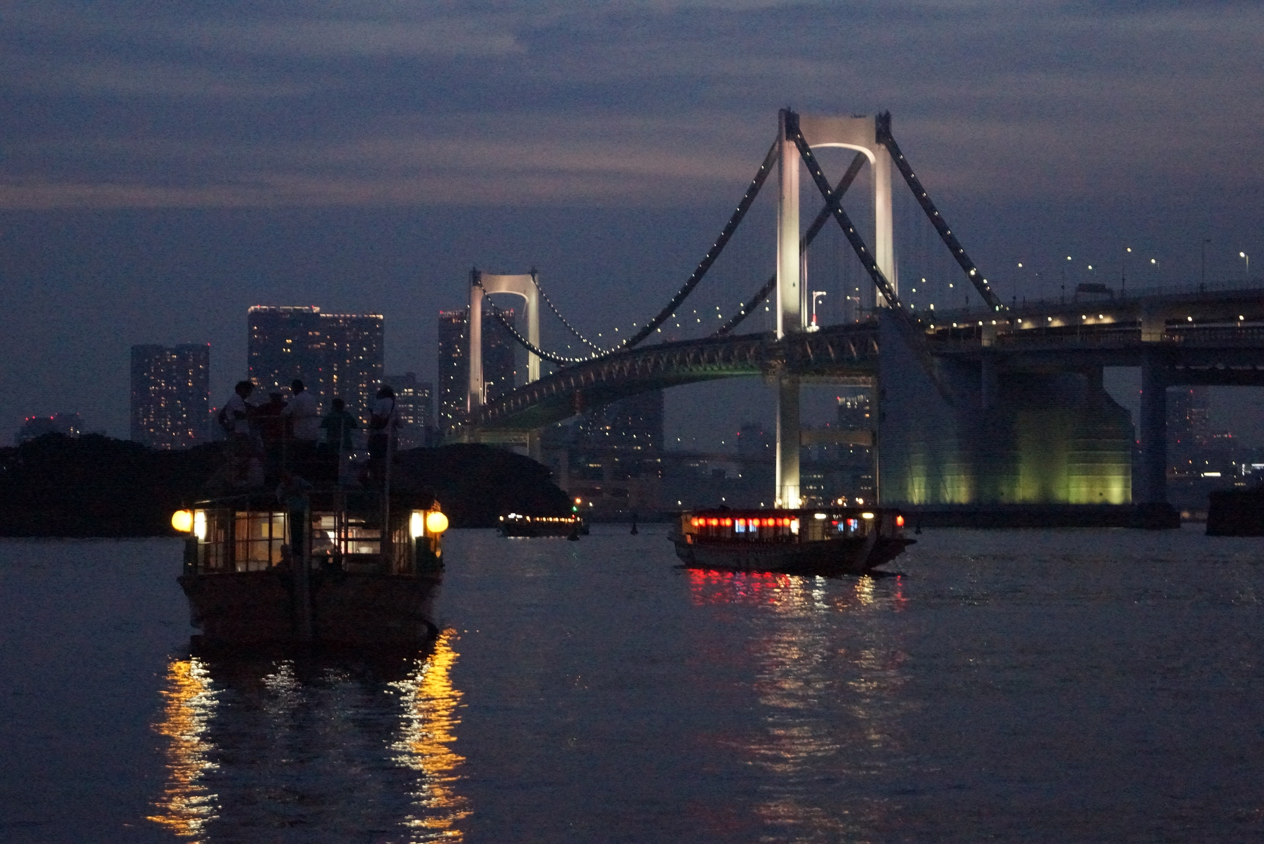 ライトアップされた橋と水辺に浮いている船