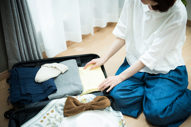 スーツケースにパッキングしている女性