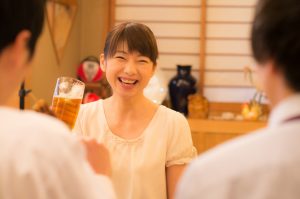 ビールジョッキを持って談笑している女性