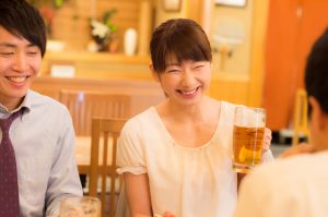 忘年会でビールを飲む女性