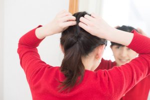 自分でヘアアレンジを加える女性