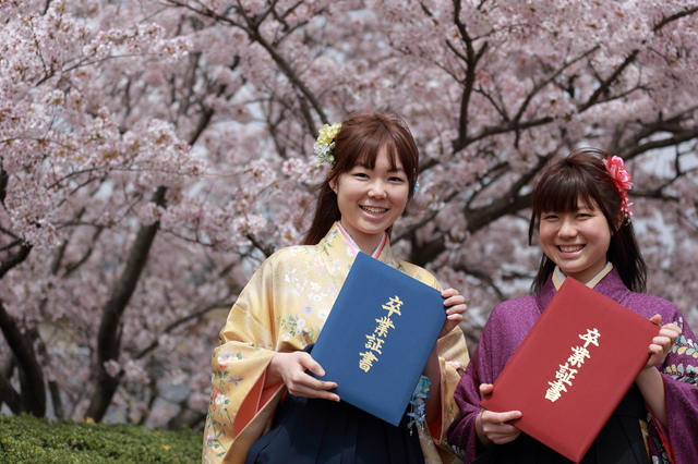 卒業証書を持つ袴姿の女性2人