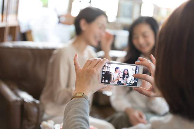 スマートフォンで写真を撮る女性