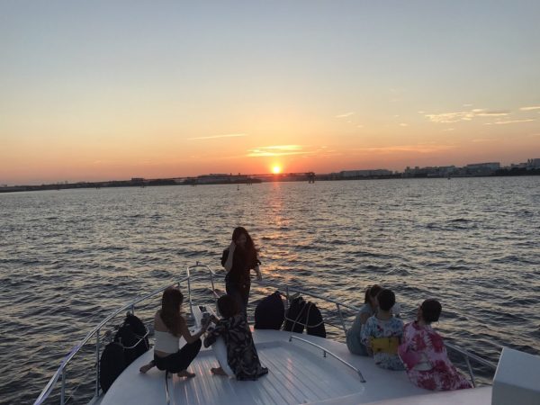 船上から水平線に沈む夕日を眺める風景