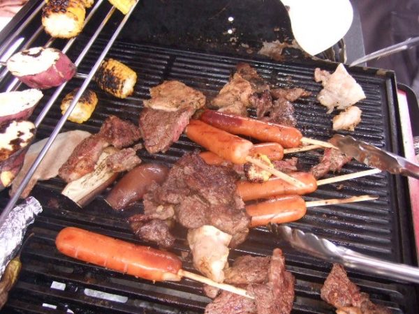 BBQコンロで肉やソーセージ、野菜などを焼いている風景