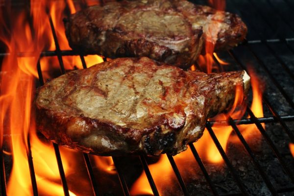 BBQコンロで分厚い骨付き肉を焼いている風景