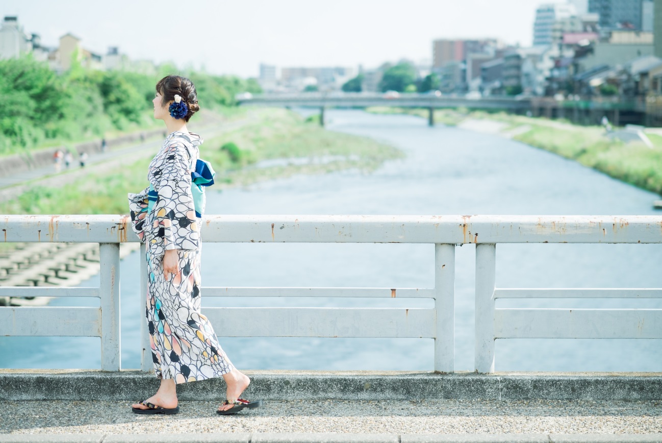 浴衣で橋を渡っている女性