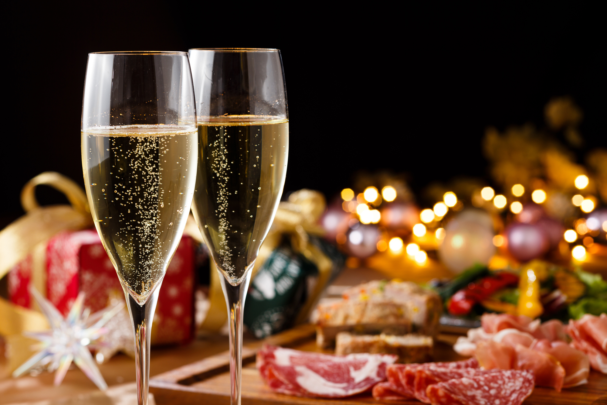 クリスマスの装飾のされたテーブルに並ぶシャンパンと料理