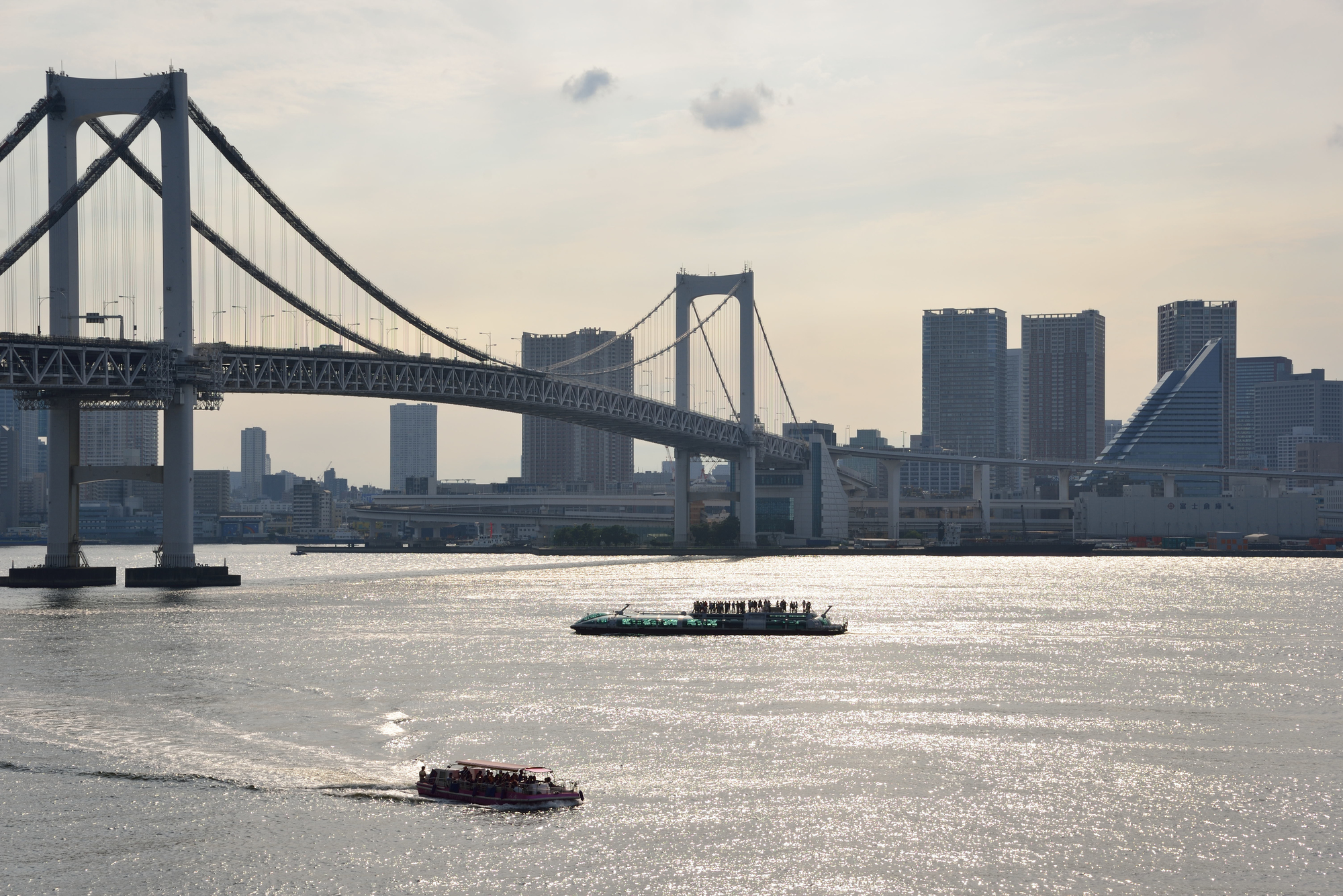 東京湾を進むクルーザーやレインボーブリッジ