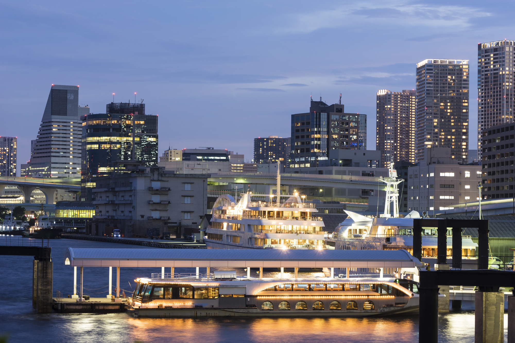 都会の夜景と停泊中の大きなクルーザー