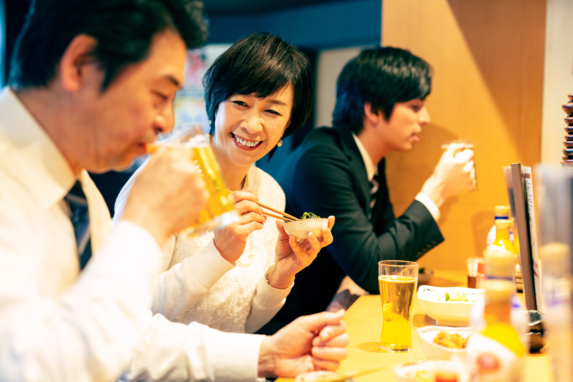 居酒屋カウンターで会食の男女