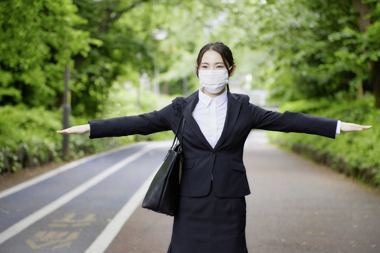 女性が手を広げて距離を示す