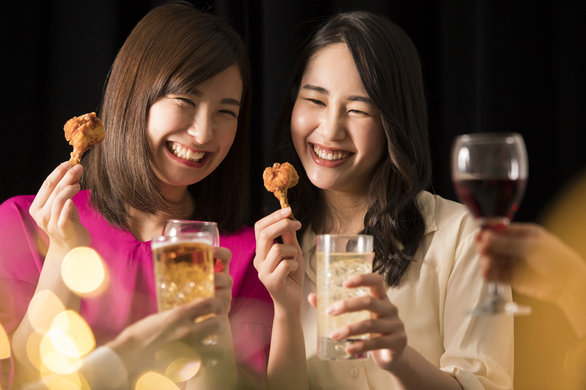 女性二人でお酒を飲みながら食べるシーン