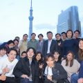 企業懇親会でスカイツリーを背景にして集合写真を撮影する