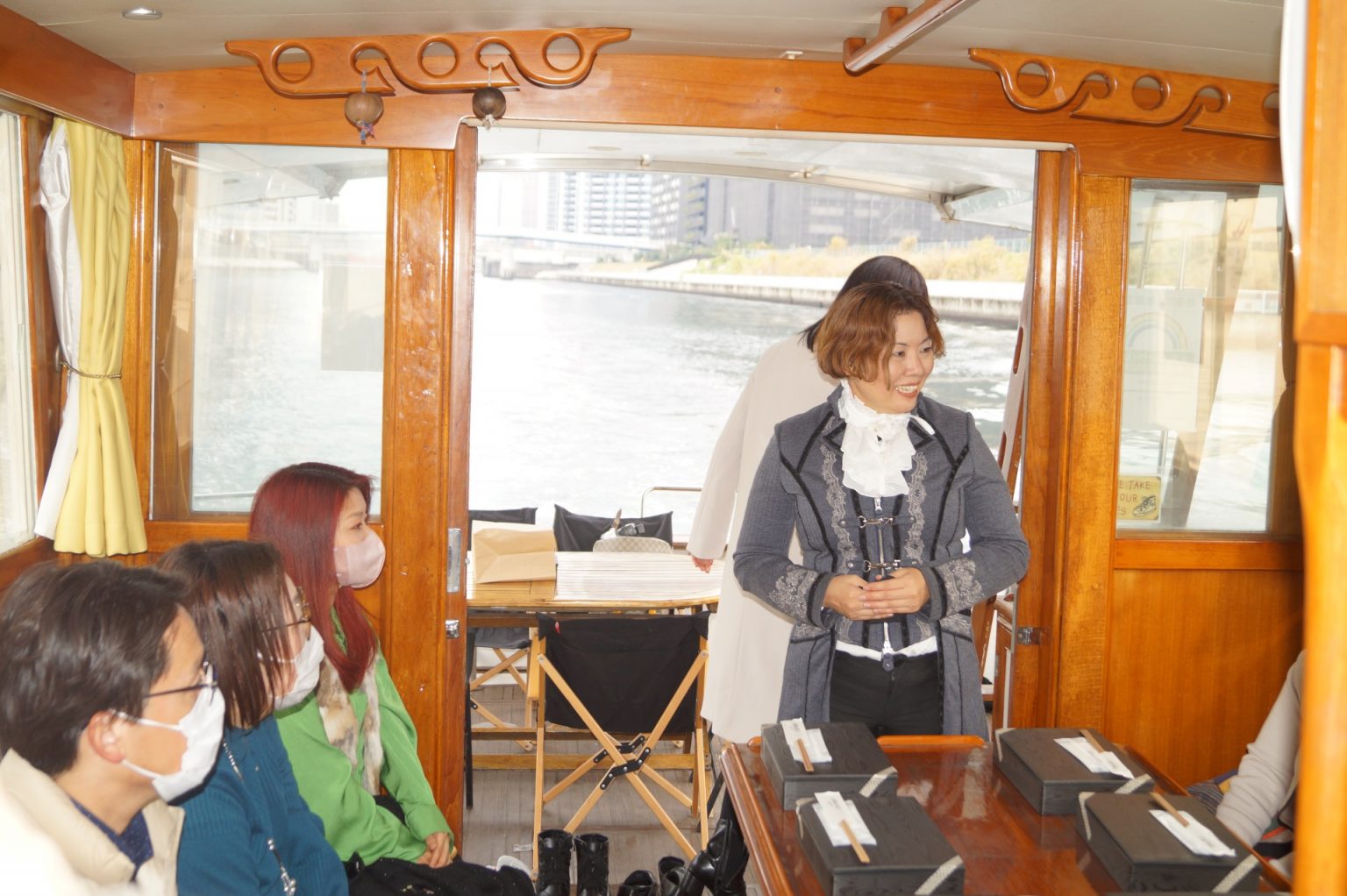 グランドバンクス号船内でパーティーはじまりの挨拶を行う女性