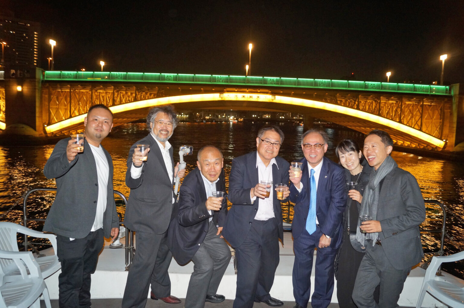 隅田川にかかる橋のライトアップとクルージングを楽しむ人たち