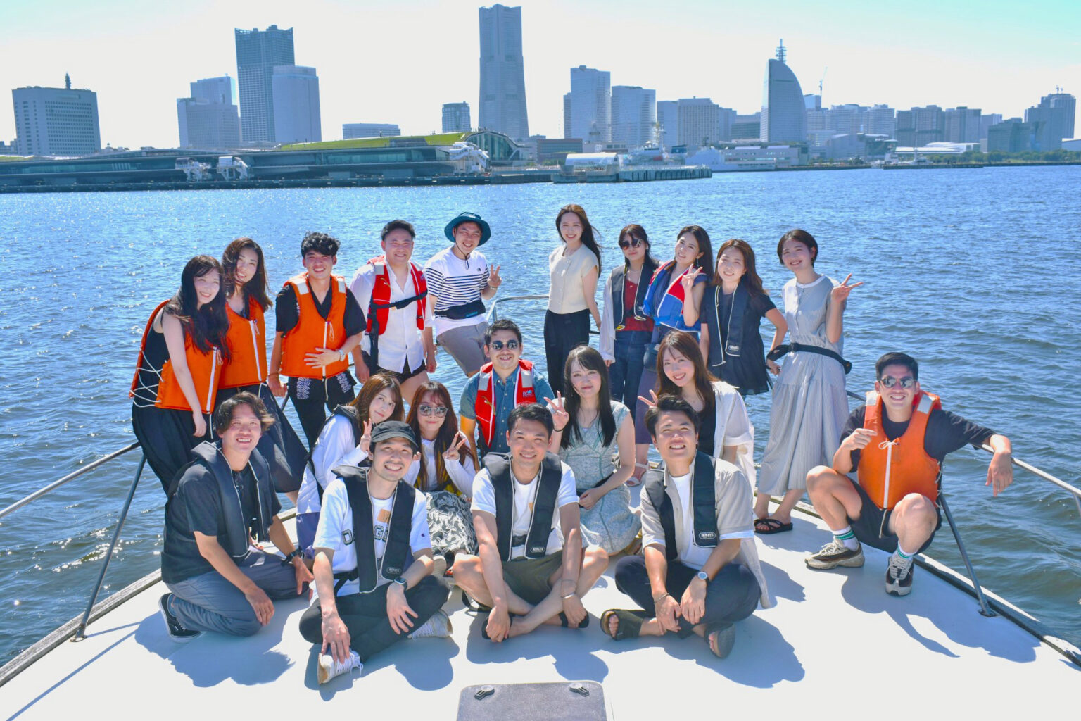 オリエンタルパール号のデッキで横浜の海辺を背景に集合写真を撮影