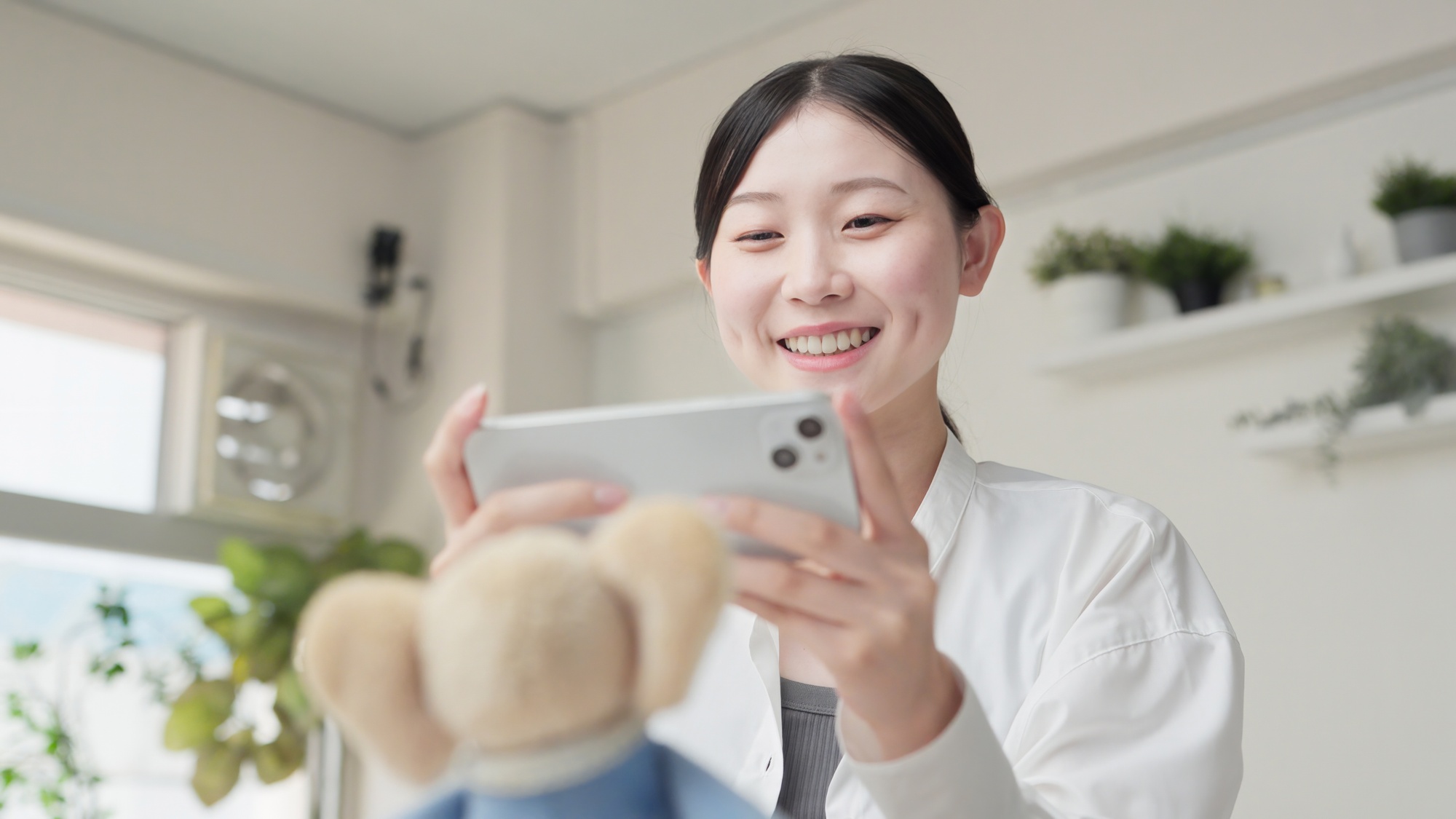 ぬいぐるみの写真を撮る女性