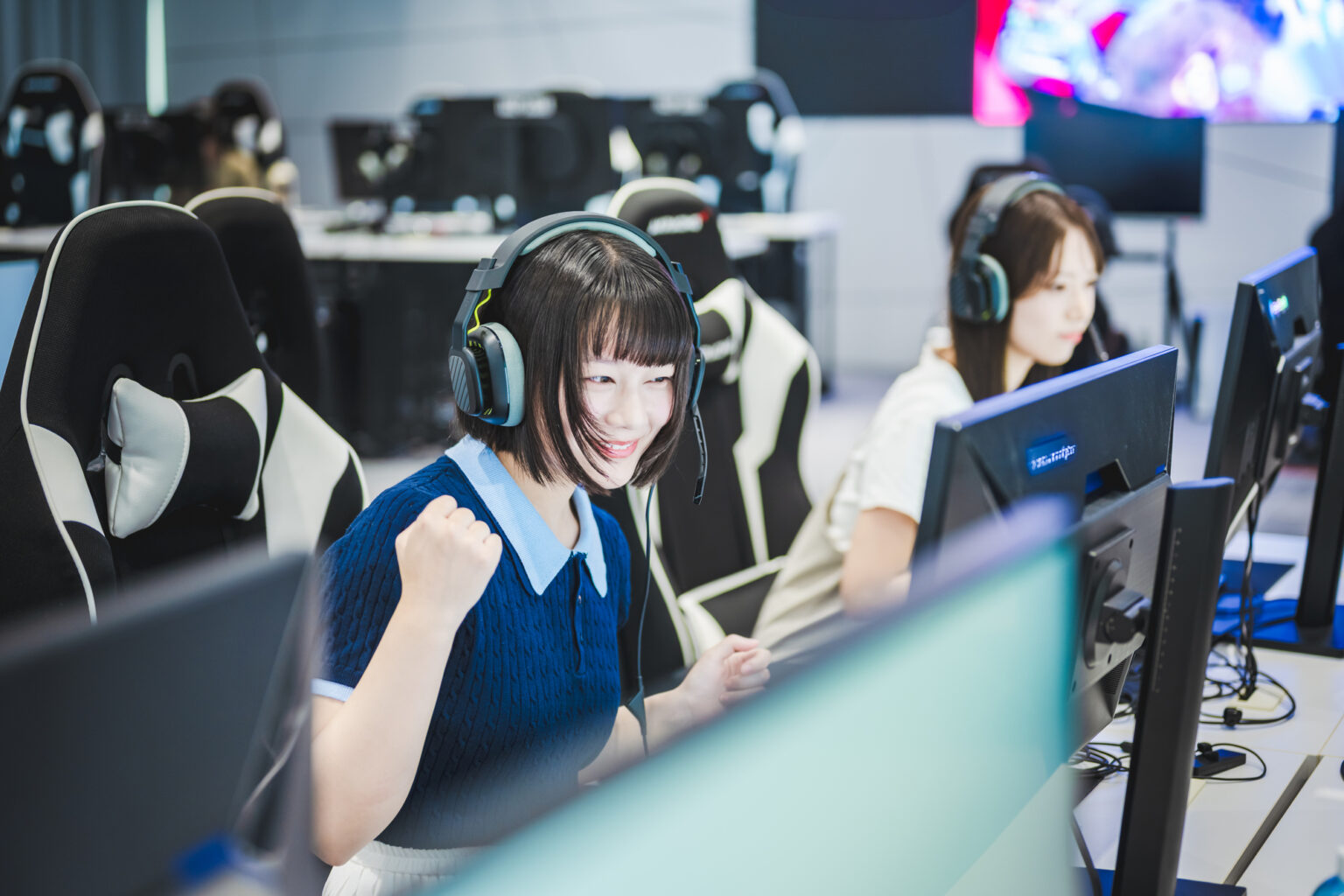 eスポーツでガッツポーズする女子学生
