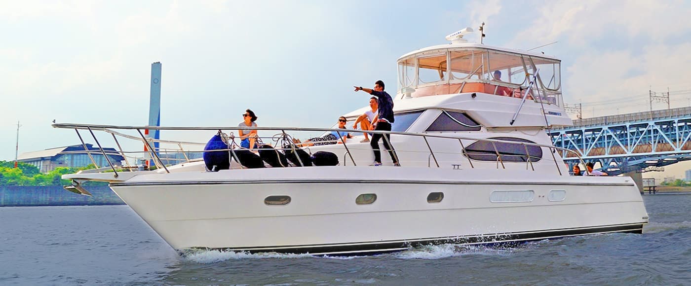 海を進むクルーザーとフロントデッキに乗船している男女