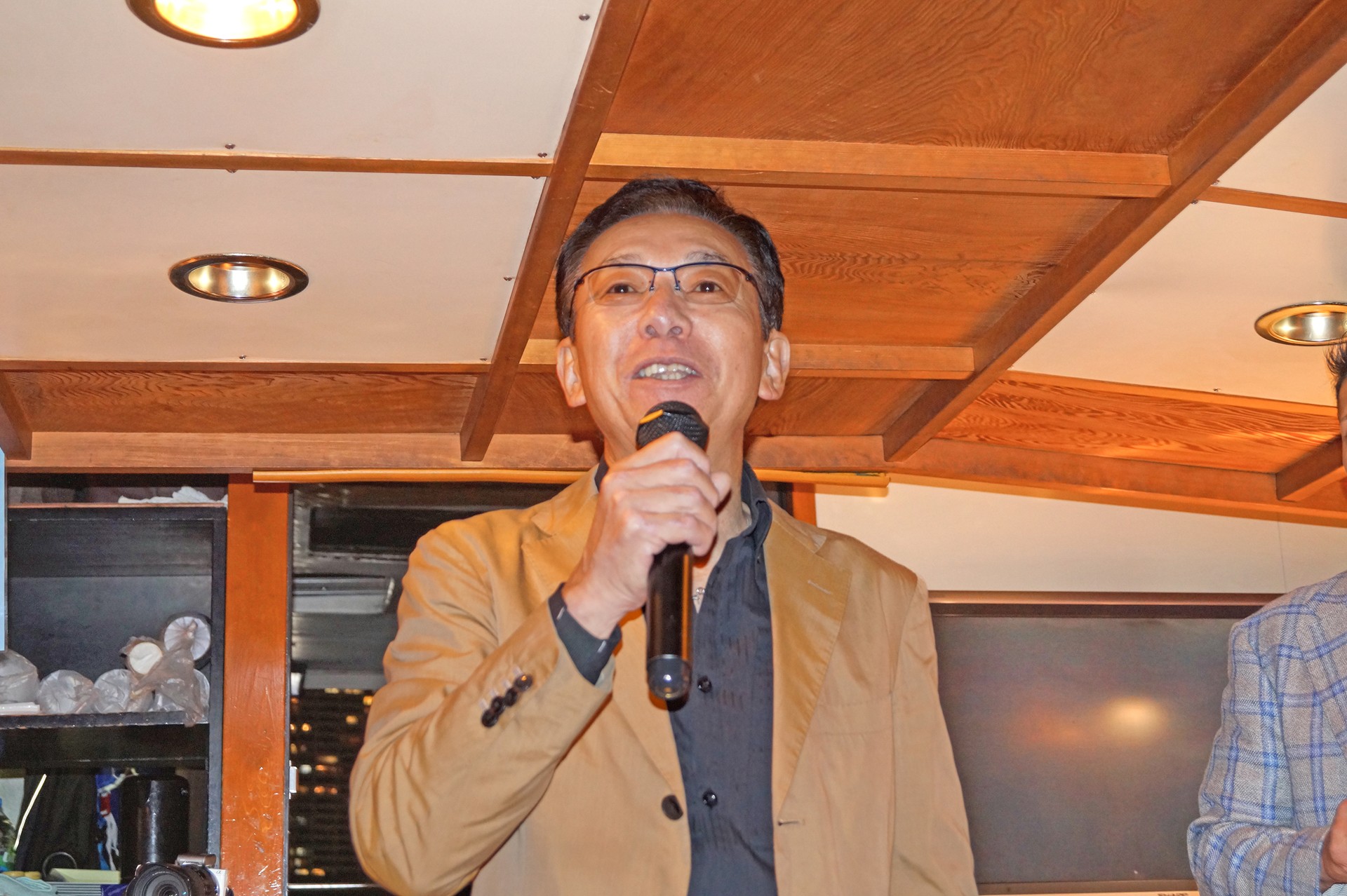 マイクを使って挨拶する男性