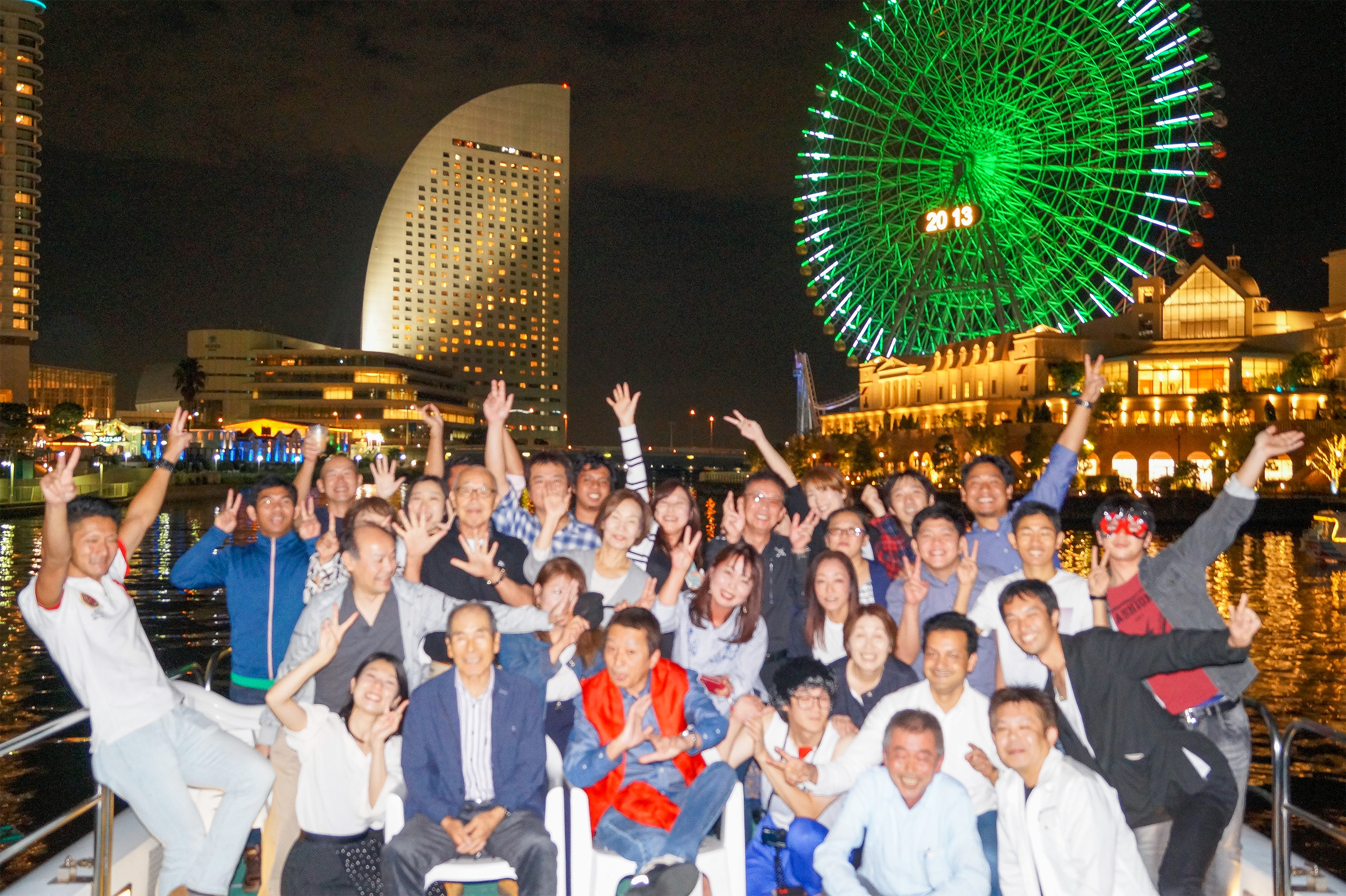 横浜の夜景をバックにデッキで集合写真