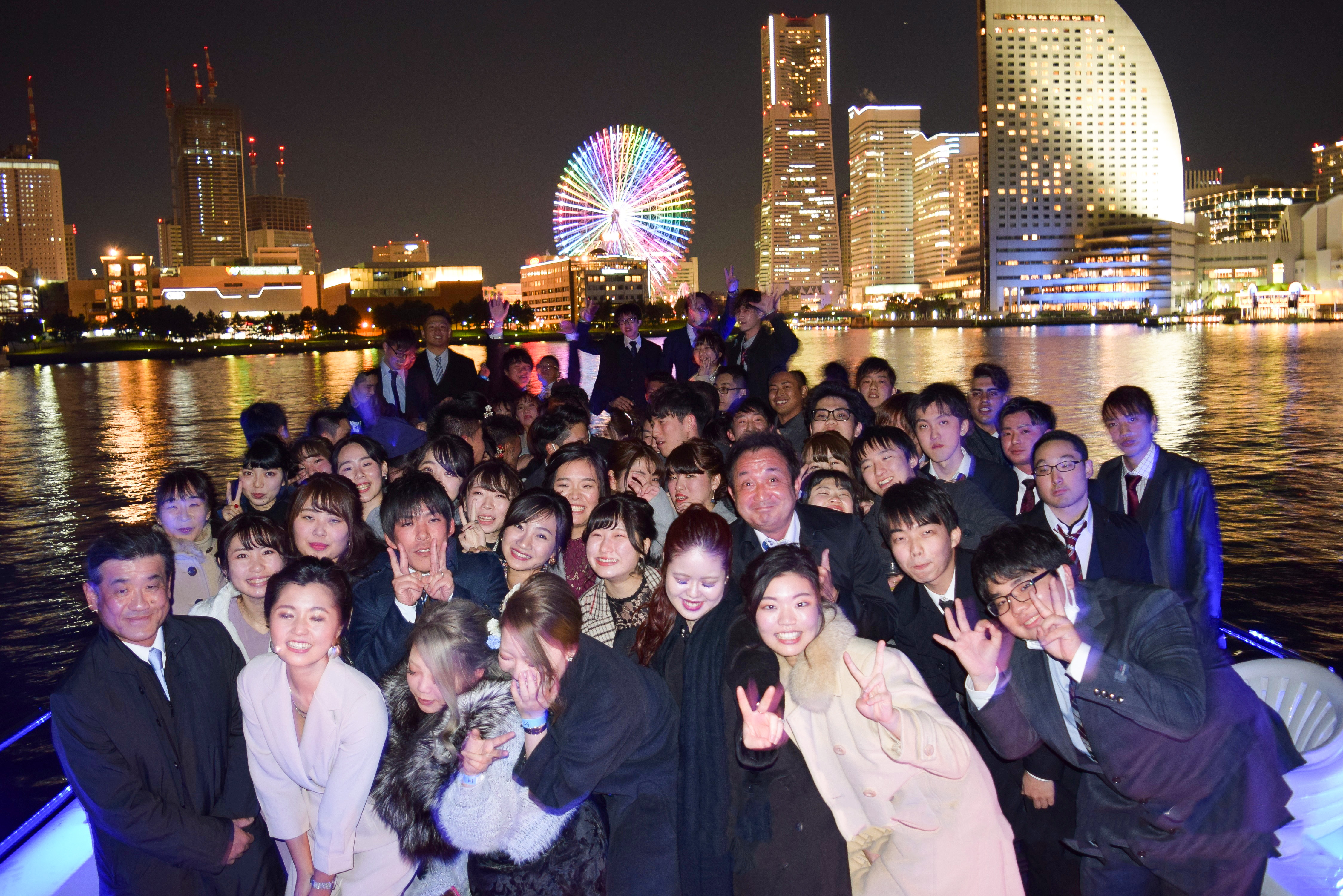 横浜の夜景をバックにデッキで集合写真