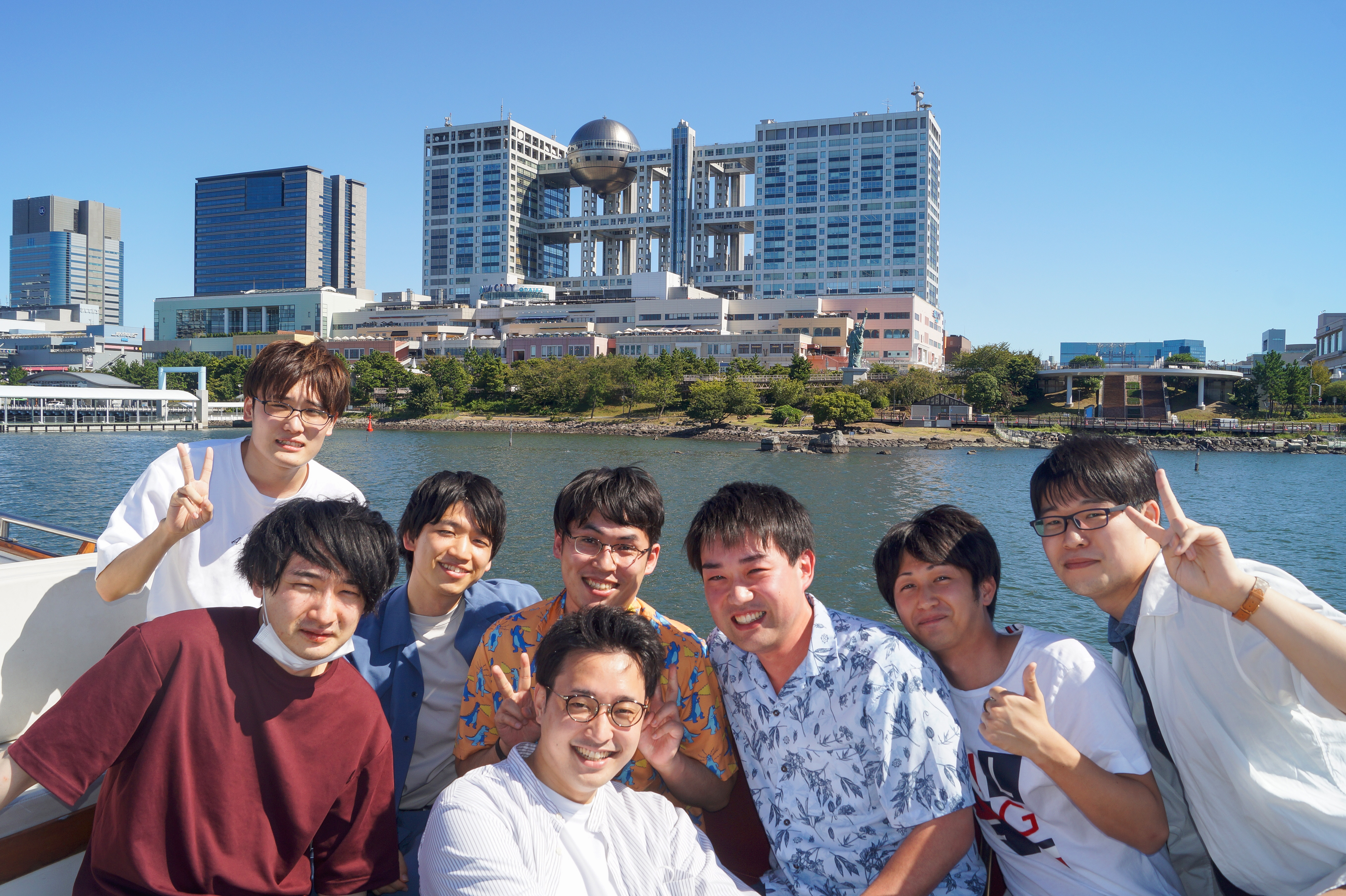 フジテレビをバックに集合写真 を取る男性