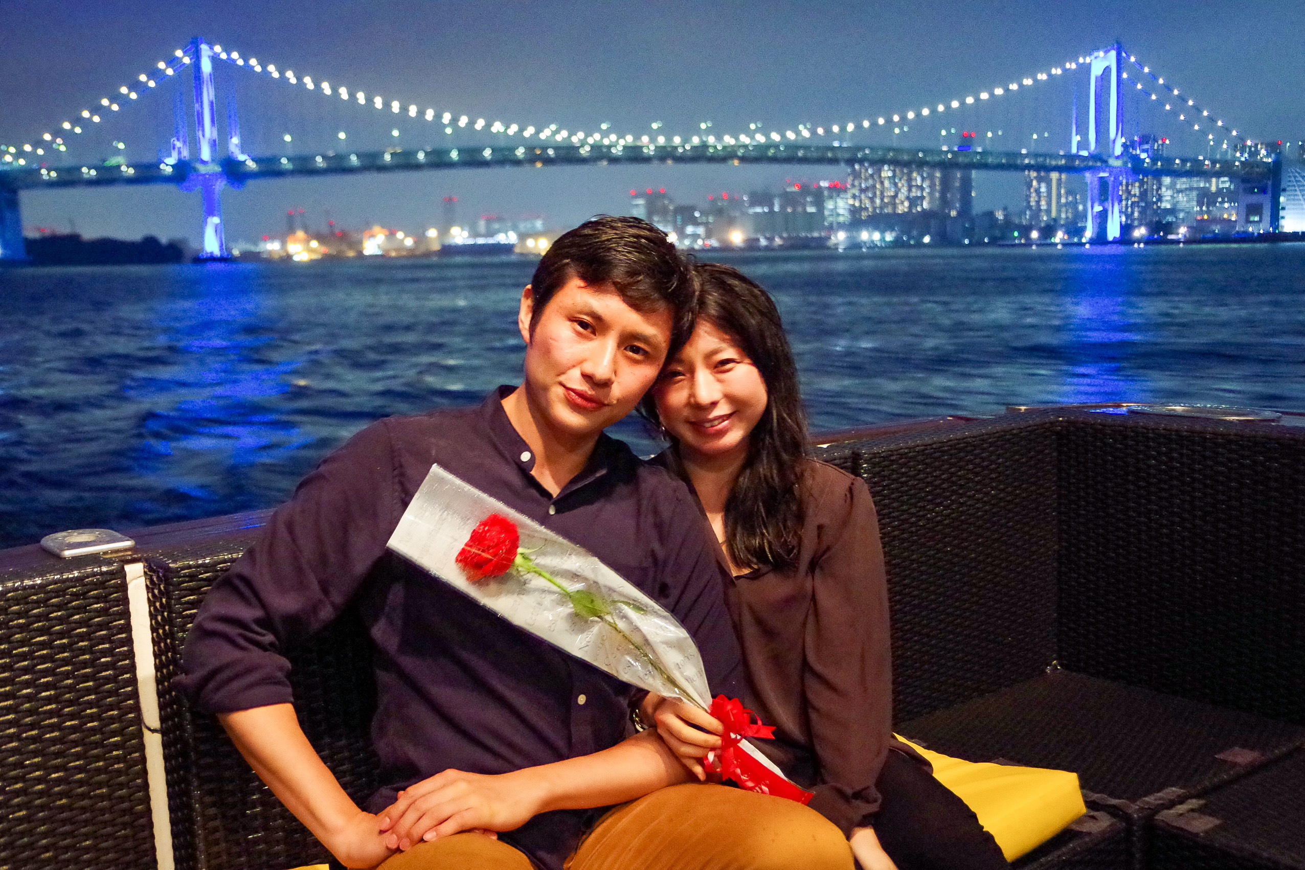 レインボーブリッジをバックに記念撮影するカップル