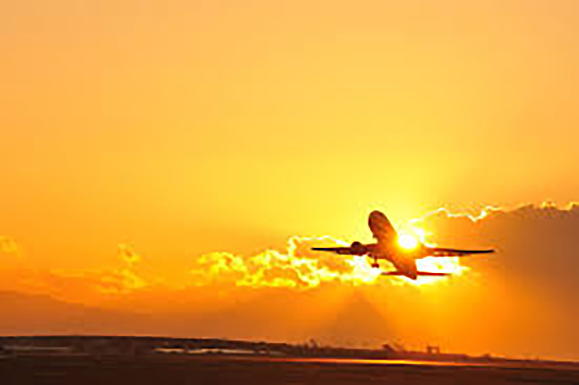 夕日の中を飛ぶ飛行機