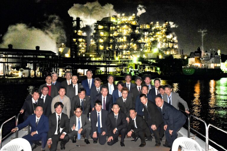 工場夜景をバックにデッキで集合写真