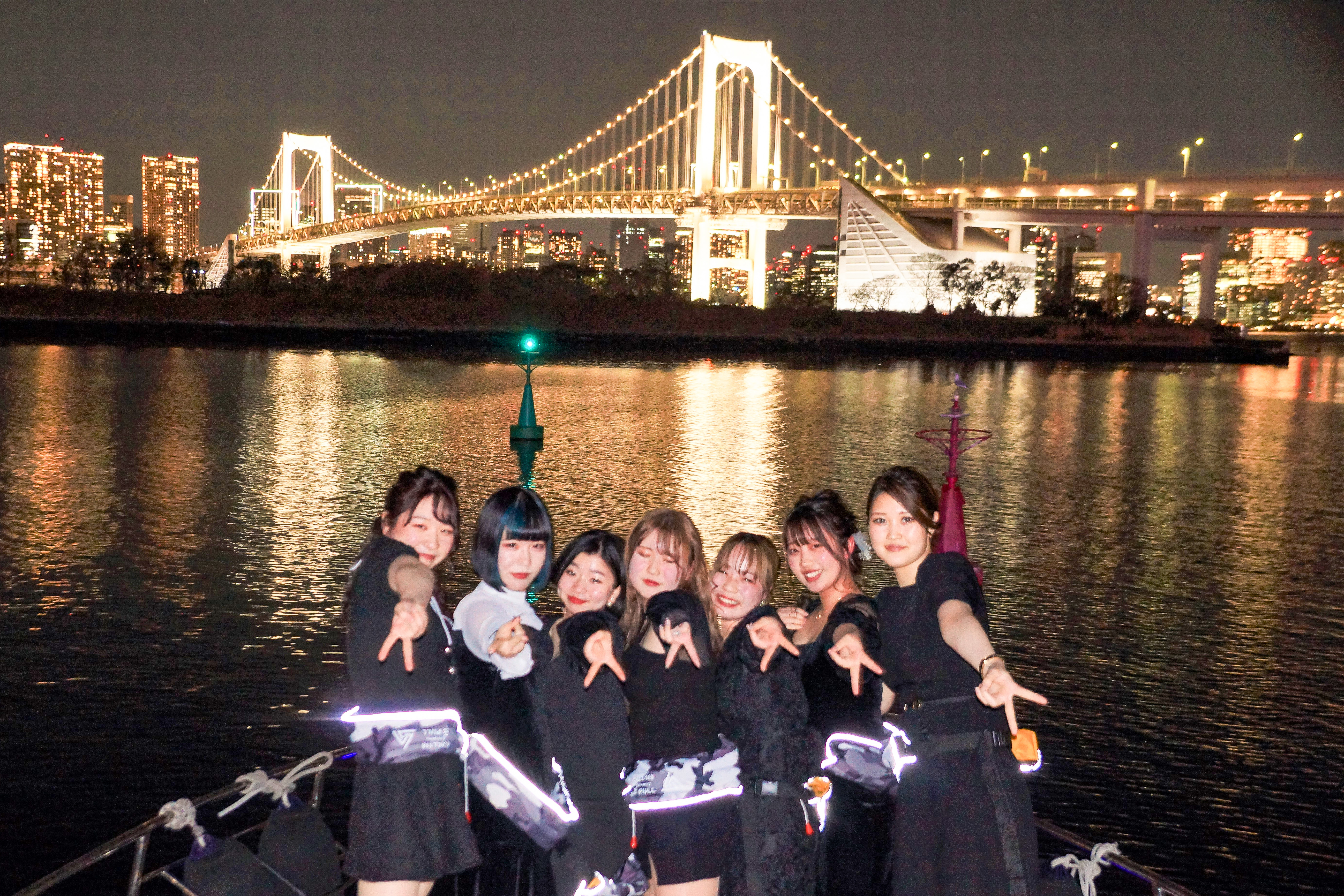 デッキでレインボーブリッジをバックに集合写真