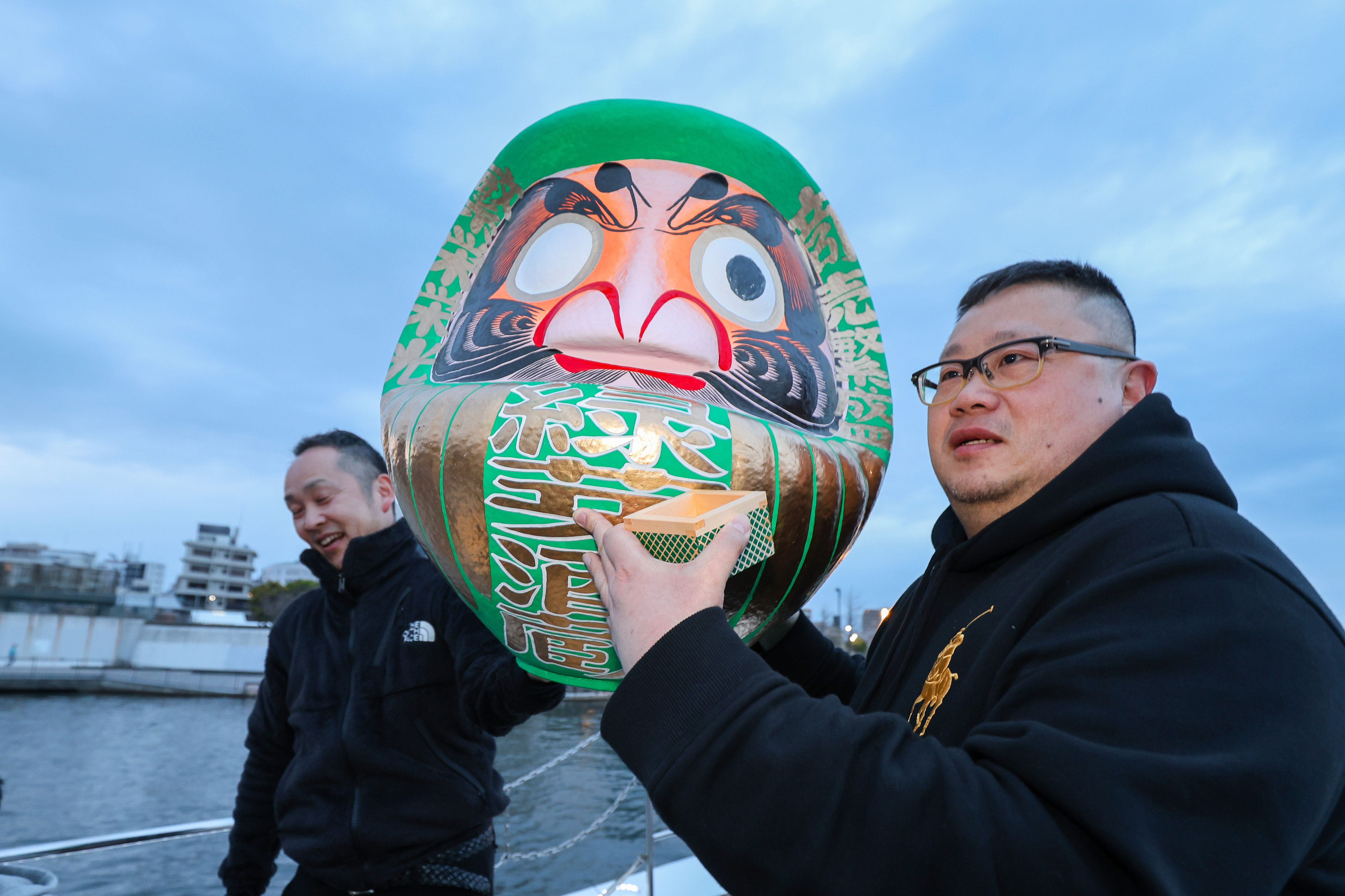 達磨を掲げる男性