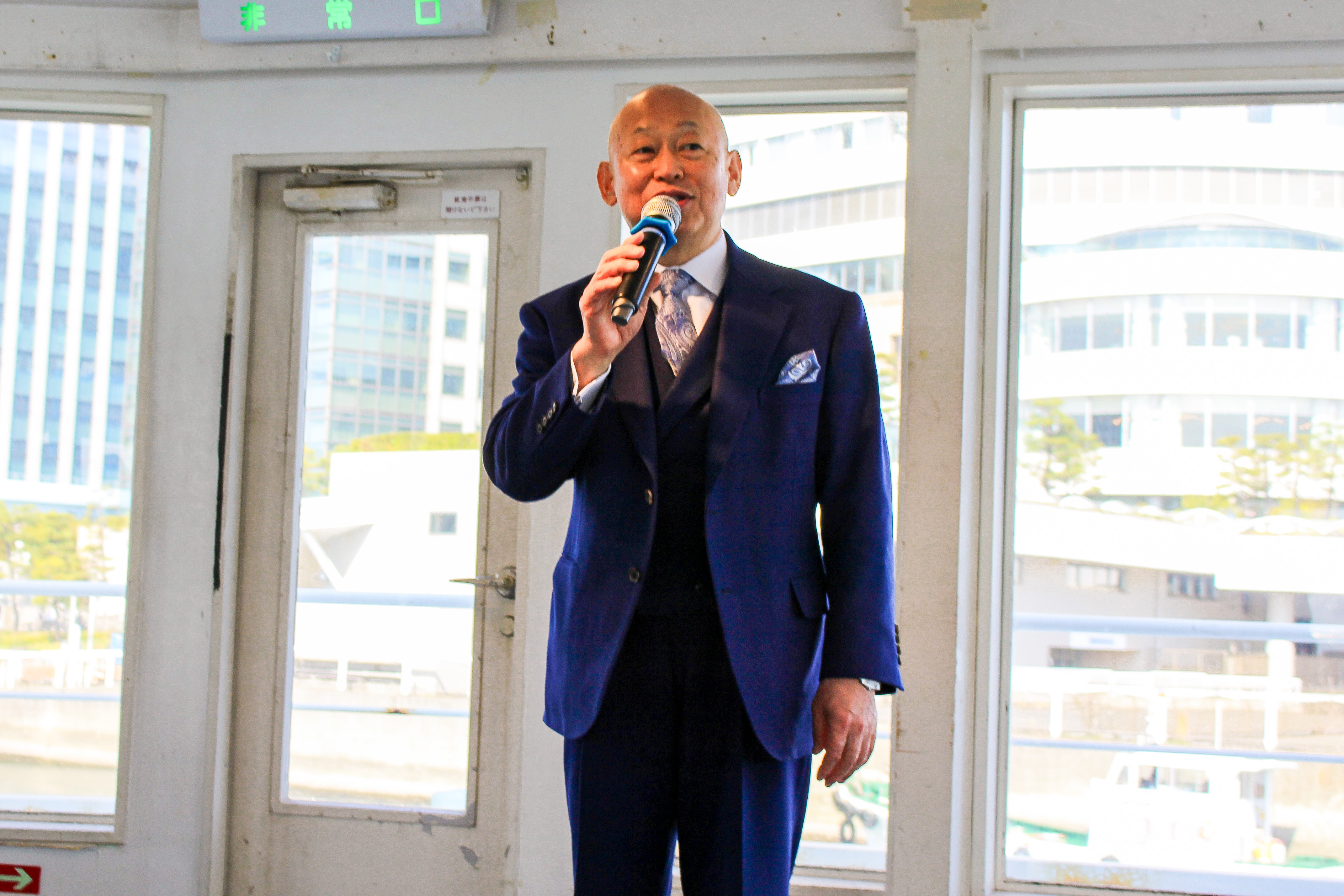 マイクで話す男性