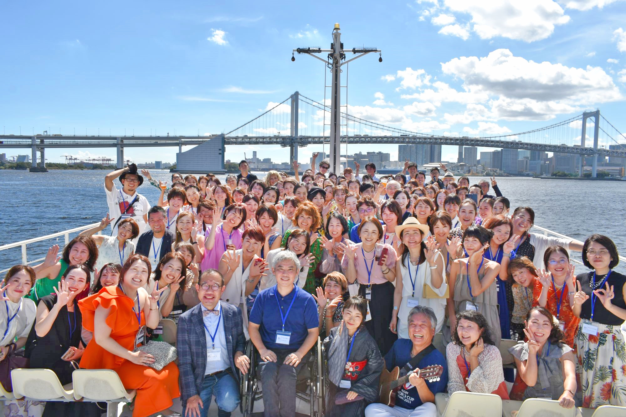 デッキでレインボーブリッジをバックに集合写真