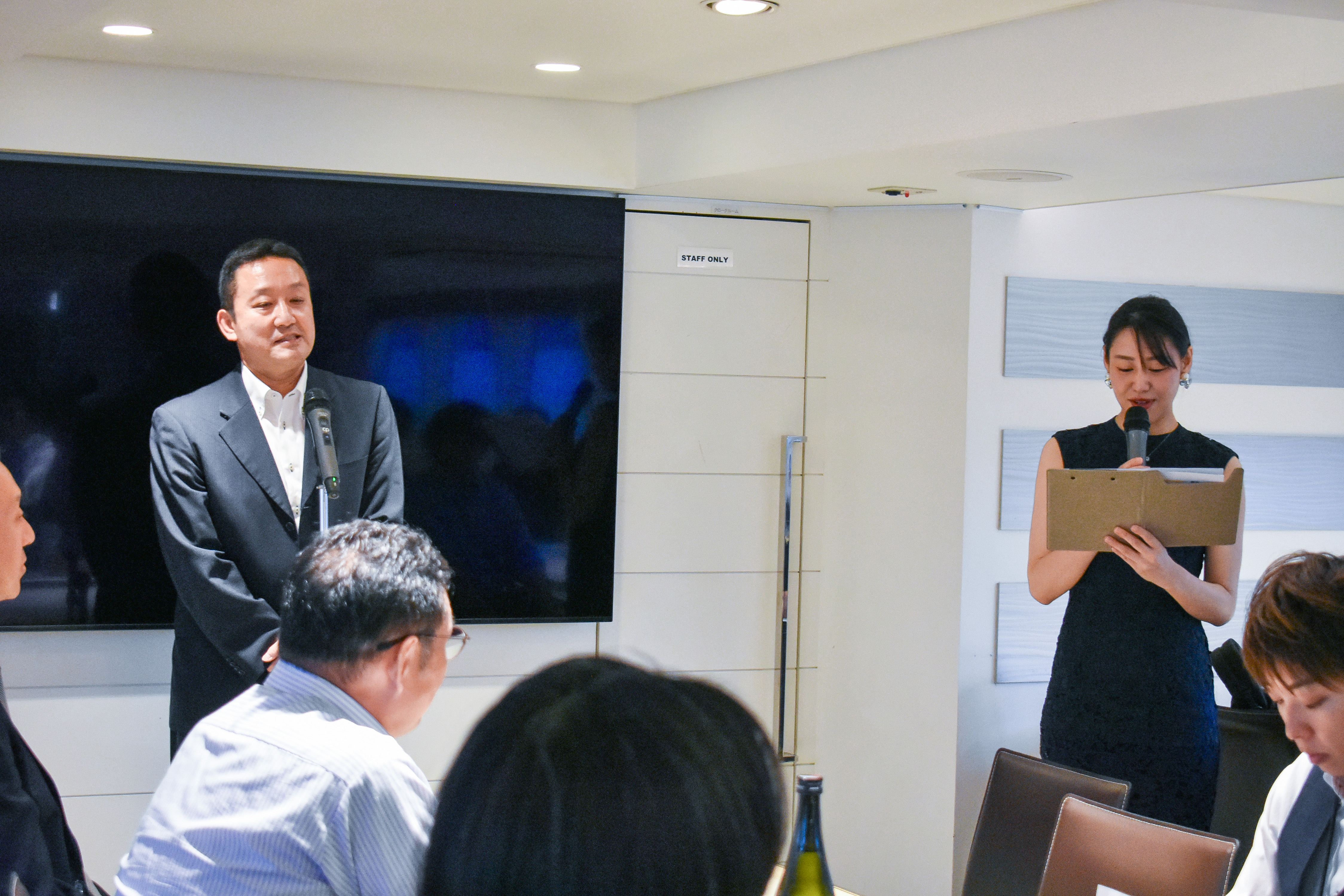 マイクであいさつする男性