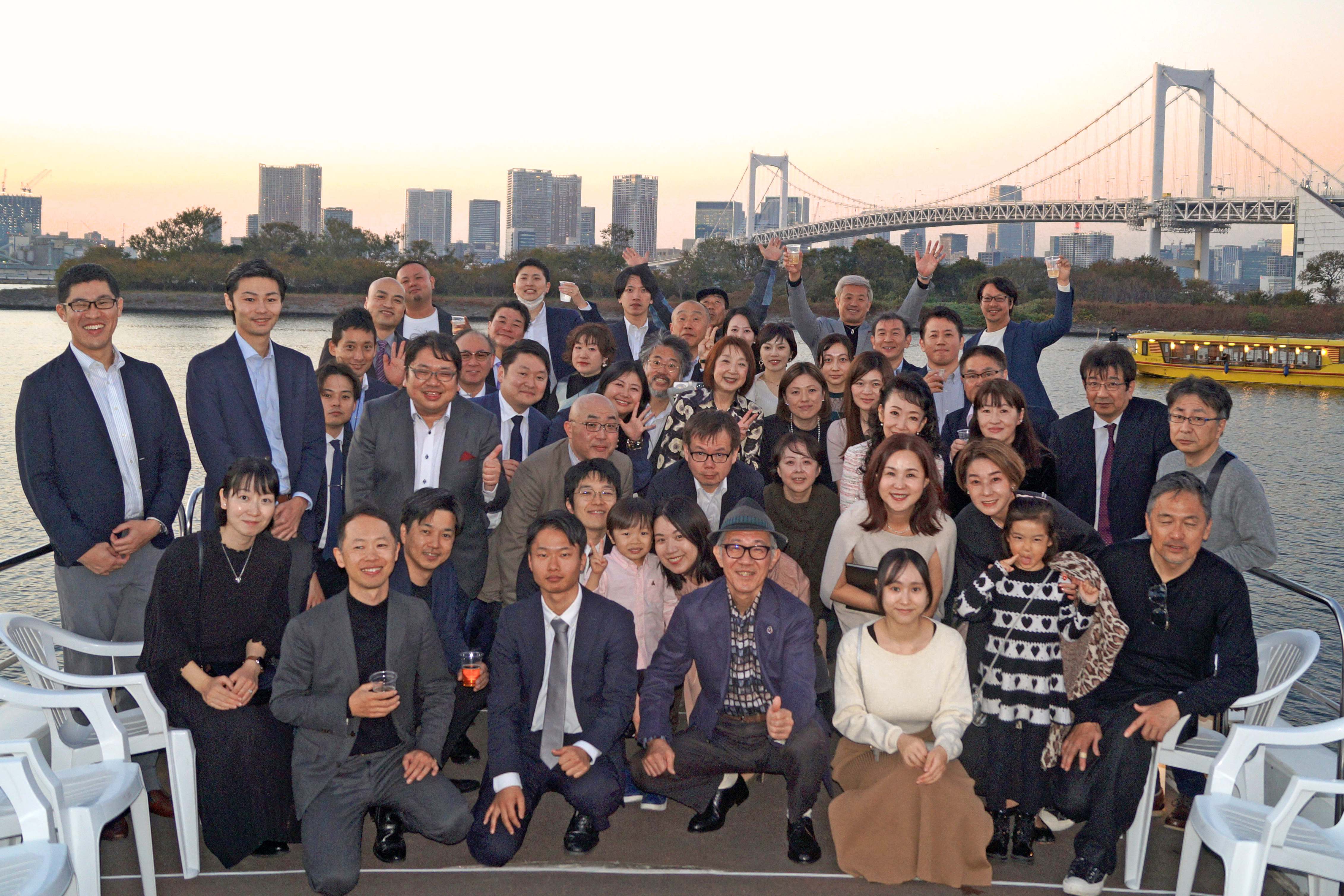 デッキでレインボーブリッジを背景に集合写真