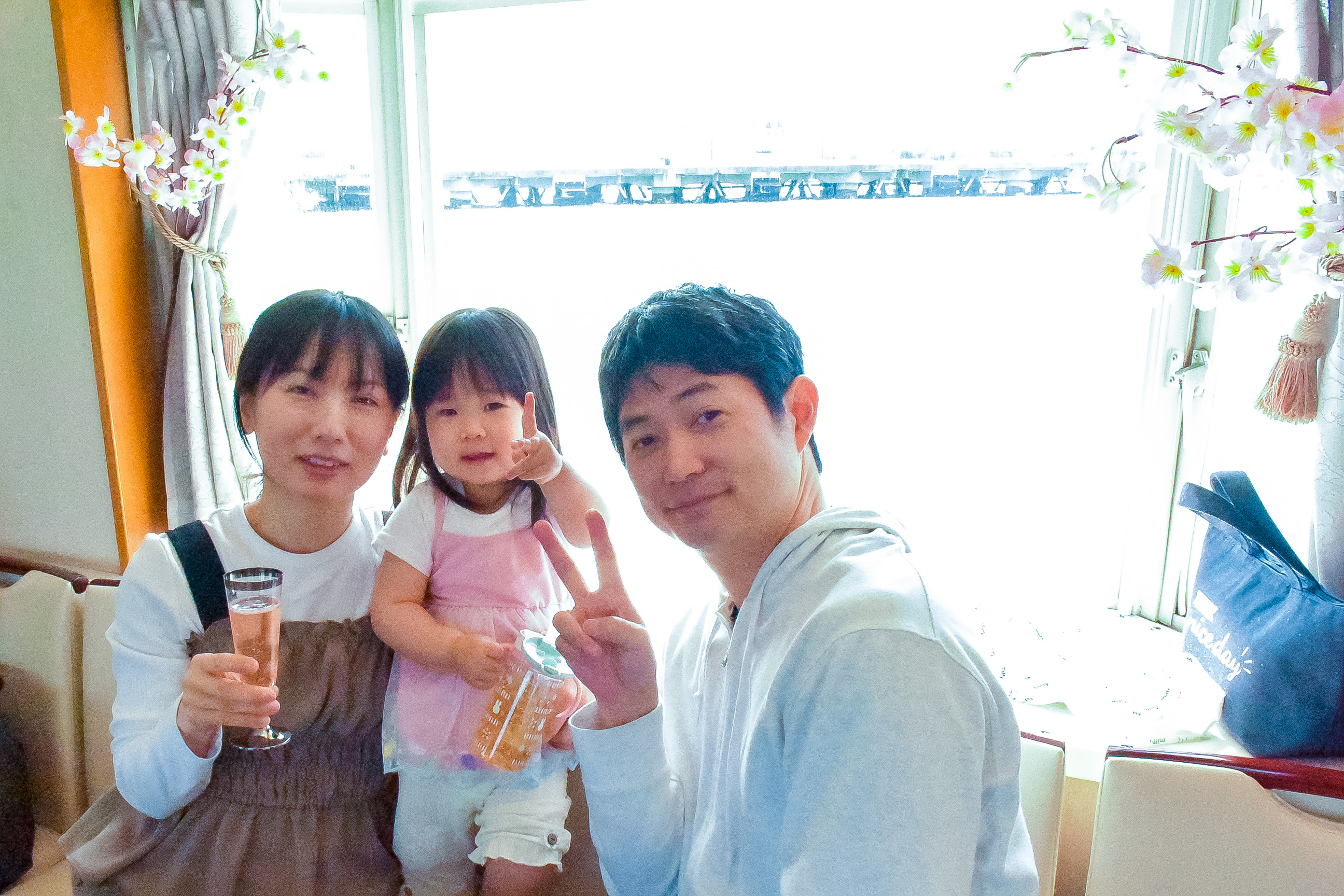 桜装飾された船内で家族写真